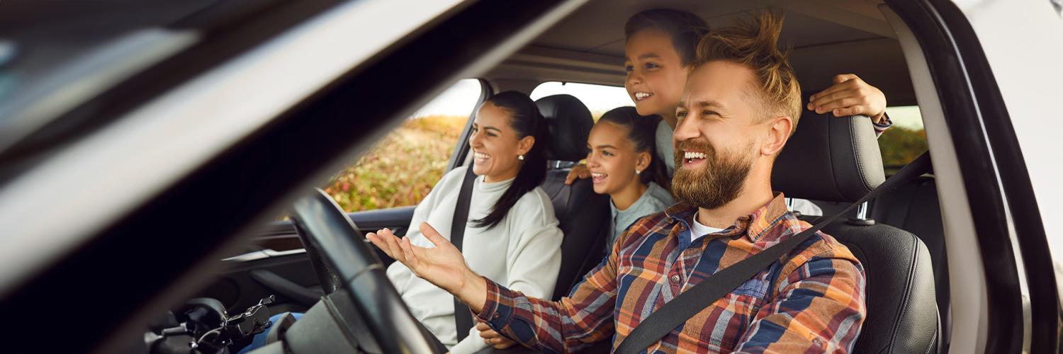 Familia feliz, dentro de un vehículo